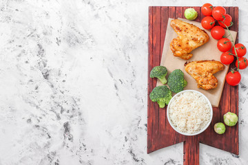 Tasty rice and chicken with vegetables on white table