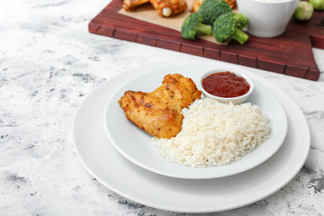 Tasty rice and chicken with sauce on white table