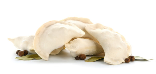 Raw dumplings with spices on white background