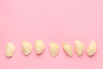 Raw dumplings on color background
