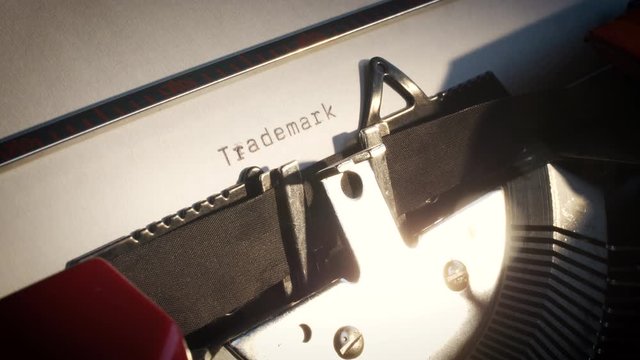 old typewriter with text trademark revealed on white paper
