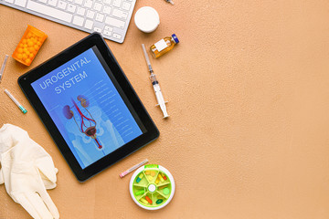 Tablet computer with picture of urogenital system on screen, medicines and gloves on color...