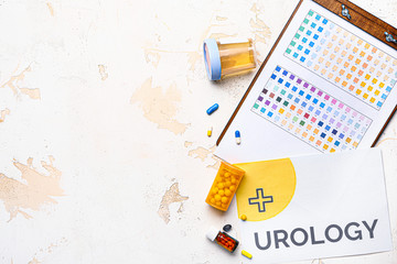 Paper sheet with text UROLOGY, pills and urine sample on light background