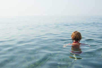 Girl relaxing in the crystal clear waters of Black sea, Crimea