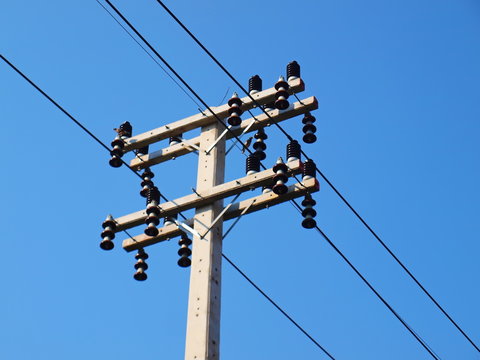 New electricity poles and high voltage cables on the poles Replacing the electric pole With a new set of arms and insulators to support the growth of urban communities On the blue sky background