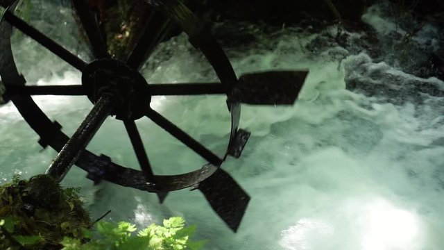 SLOWMO - Detail shot of old rustic water mill wheel in pristine clear fast flowing creek Putaruru Blue Spring, New Zealand