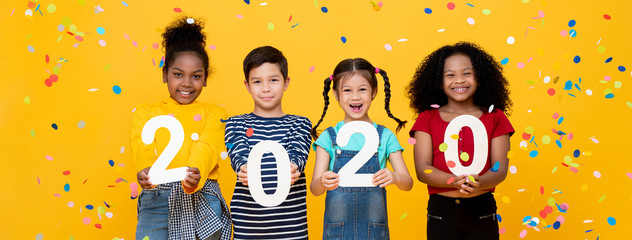 Cute smiling mixed race children showing numbers 2020 celebrating new year