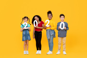 Cute mixed race kids smiling and holding 2020 numbers