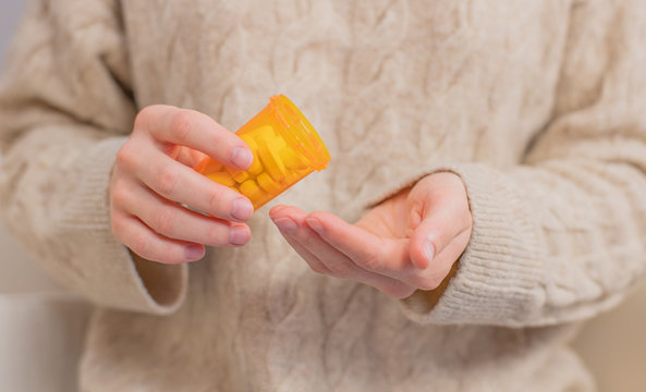 Woman takes pills vitamins. Woman is holding a jar of pills