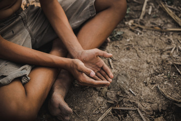 hands poor child or beggar begging you for help sitting at dirty slum. concept for poverty or...
