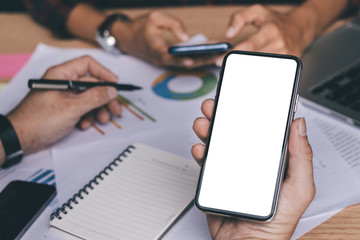 Mockup image blank white screen cell phone.man hand holding texting using mobile on desk at officebackground empty space for advertise text.people contact marketing business,technology 