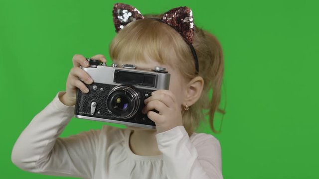 Girl in cat headband taking pictures on an old retro photo camera. Chroma Key