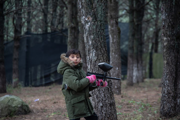 Obraz premium boy with green jacket playing gotcha in the woods among trees