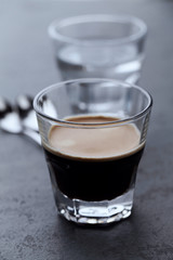 Coffee in glass cup on dark stone background. Close up.