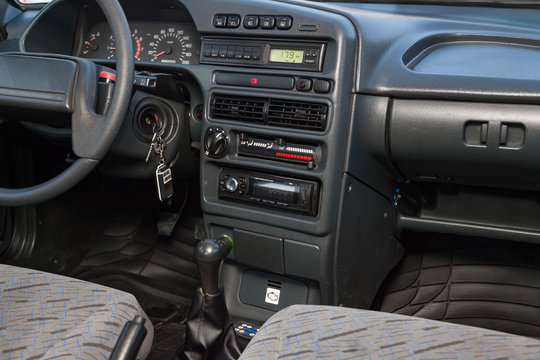 The interior of the car lada 2114 samara with a view of the steering wheel, dashboard, seats and multimedia system with light gray trim. Auto service industry.