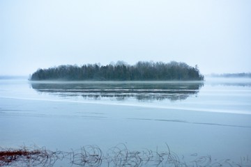 island on frozen lake in winter