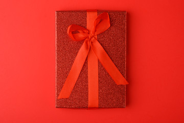 Red gift on a red background. Holiday, birthday or Valentine's day. Love and romance. Minimalism.
