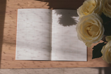 empty message in schedule book of calendar with white rose flower put on table work
