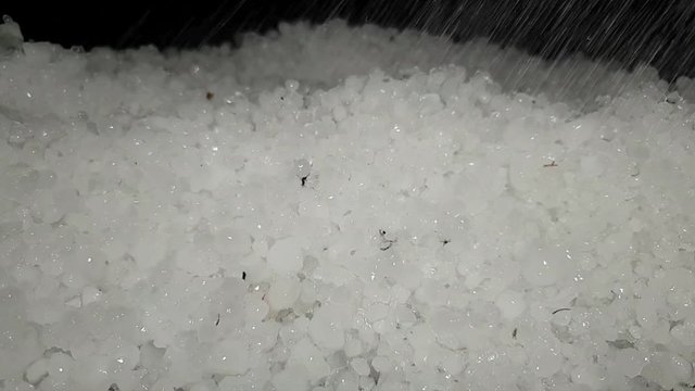White hail storm ice balls being melted with water drops