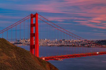 Panorama of the Golden Gate bridge with the Marin Headlands and San Francisco skyline at colorful sunset, California