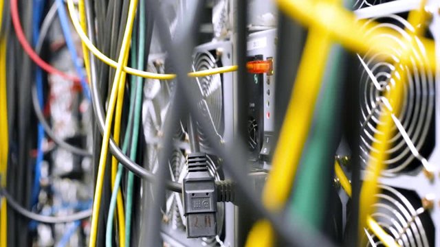Close-up of multicolored cables with computer equipment. Stock footage. Data center equipment with many connected and tangled cables