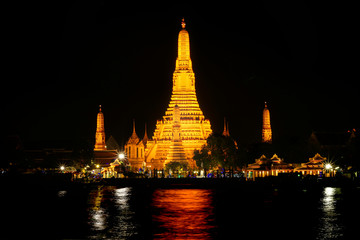 Beautiful view of Wat Arun Temple or Temple of the Dawn on the Chao Phraya river banks at night. The famous landmarks of Bangkok, Thailand.