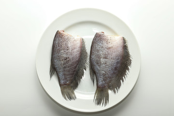 Dried Gourami fish on white plate on white background