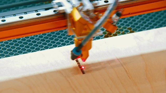 An industrial machine making marks on the wooden detail