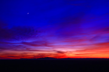 Very colorful clouds in dramatic sky. Romantic sunset at the countryside.