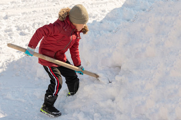 boy cleans snow in the yard