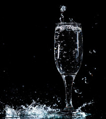 Water with splashes in a glass on a black background