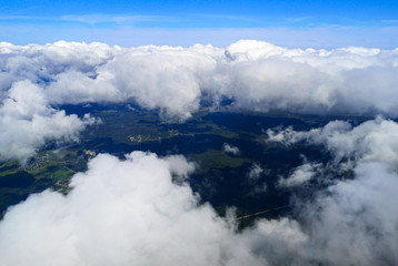 Clouds above the ground view from an airplane as a background