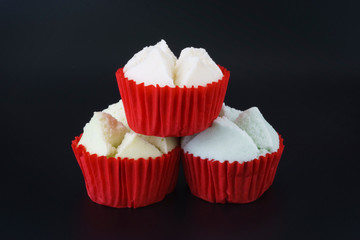 Colorful Thai steamed or Cotton wool cupcakes in red paper cup Thai dessert  on black background