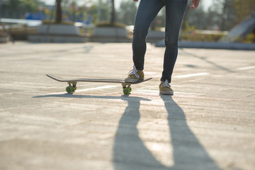 Fototapeta premium Skateboarder legs skateboarding at city