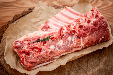 fresh rack of raw pork spare ribs seasoned with spices on slate tray with leaves at background, Horizontal composition with copy space