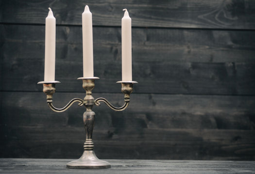 Candelabra, vintage silver candle holder on black wooden background
