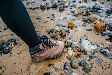 Hiking boot on sand and shingle beach 