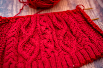 Fototapeta na wymiar Selective focus and close up red knitted project and work in progress on a hardwood floor