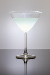 Cocktail glass on a reflective surface