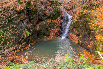 secret waterfall in autumn forest