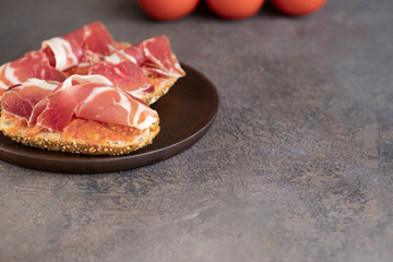 Close up of famous Spanish tapa toasted bread with tomato and Jamon, cured ham.