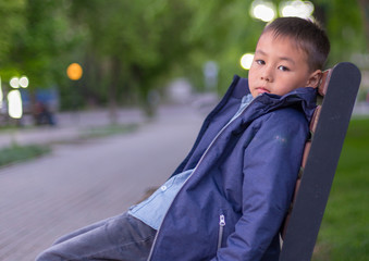 Boy sitting alone on a park bench