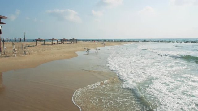View drom drone of sea coast and tourists on beach. Aerial dolly in