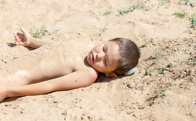 children lie naked in the sand