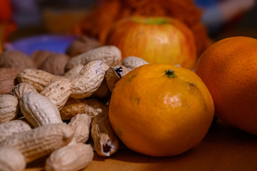 Peanuts nuts tangerines and apples on a table in close-up