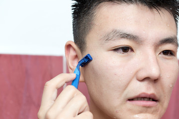 Young guy shaves his beard