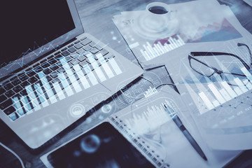 Stock market graph on background with desk and personal computer. Double exposure. Concept of financial analysis.
