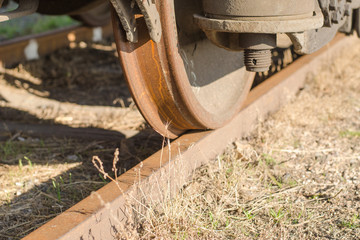 Wheel of a railway car standing on the rails close up.