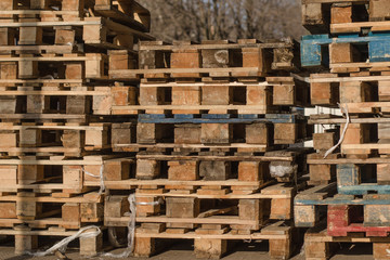 Stacks of wooden pallets. Cargo pallets. Pile of used wooden cargo shipping pallets.