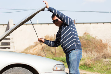 a man is repairing a car on the road